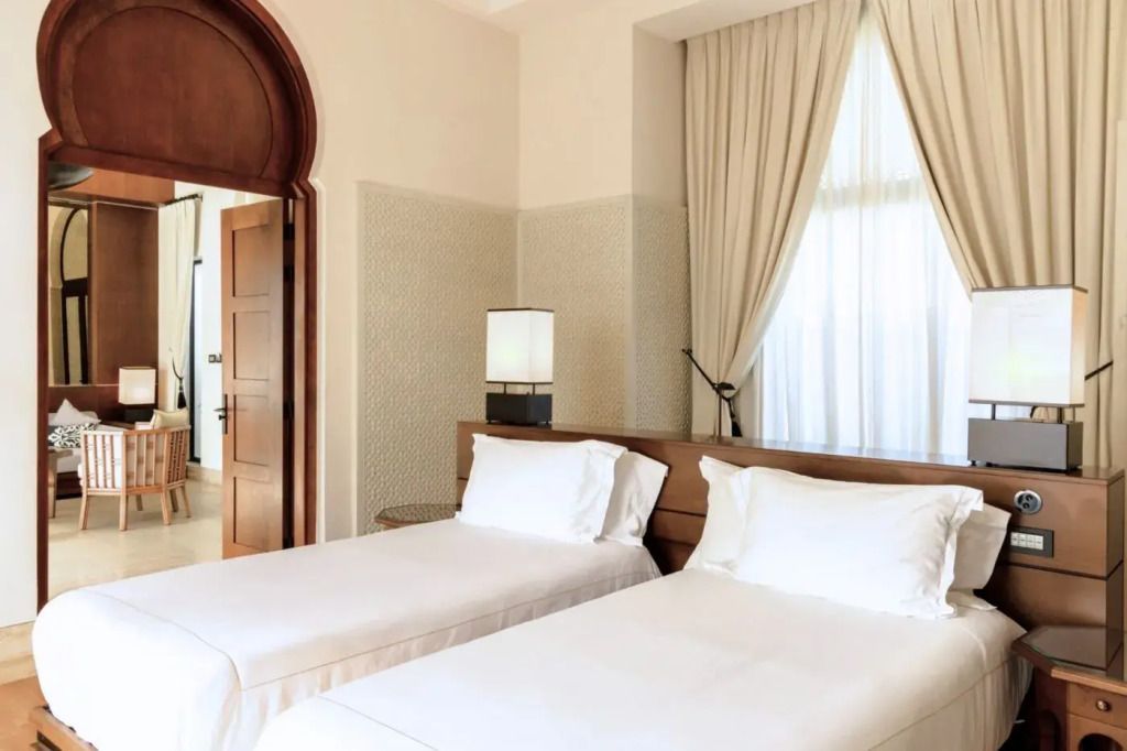 Schlafzimmer mit zwei Einzelbetten und eleganten Vorhängen