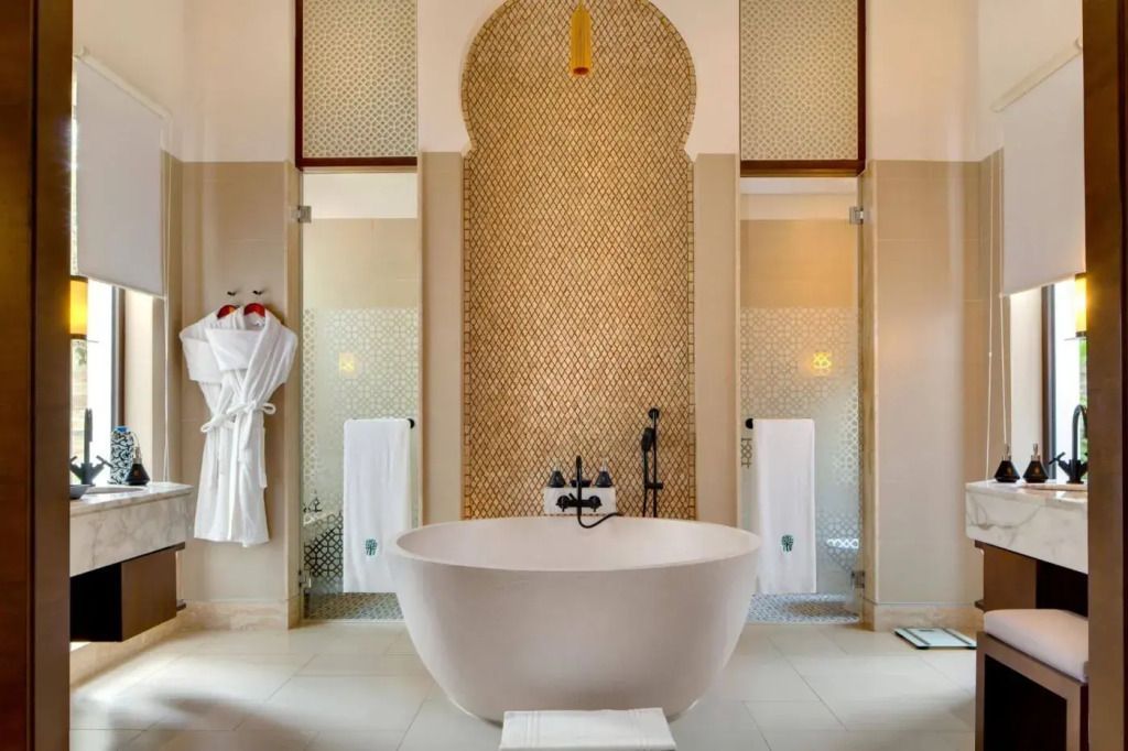 Luxuriöses Badezimmer mit freistehender Badewanne und goldenen Akzenten