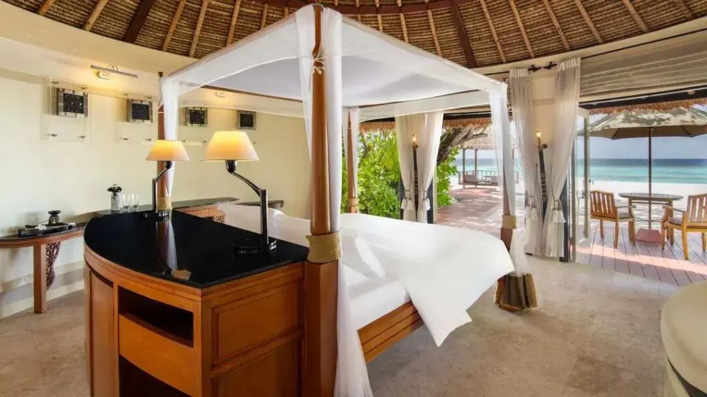 Luxuriöses Schlafzimmer mit Himmelbett und Blick auf den Strand