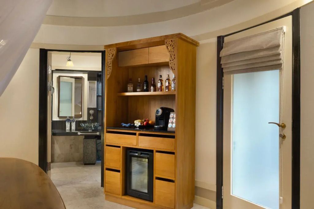 Minibar mit Holzregal und Kaffeemaschine im Zimmer