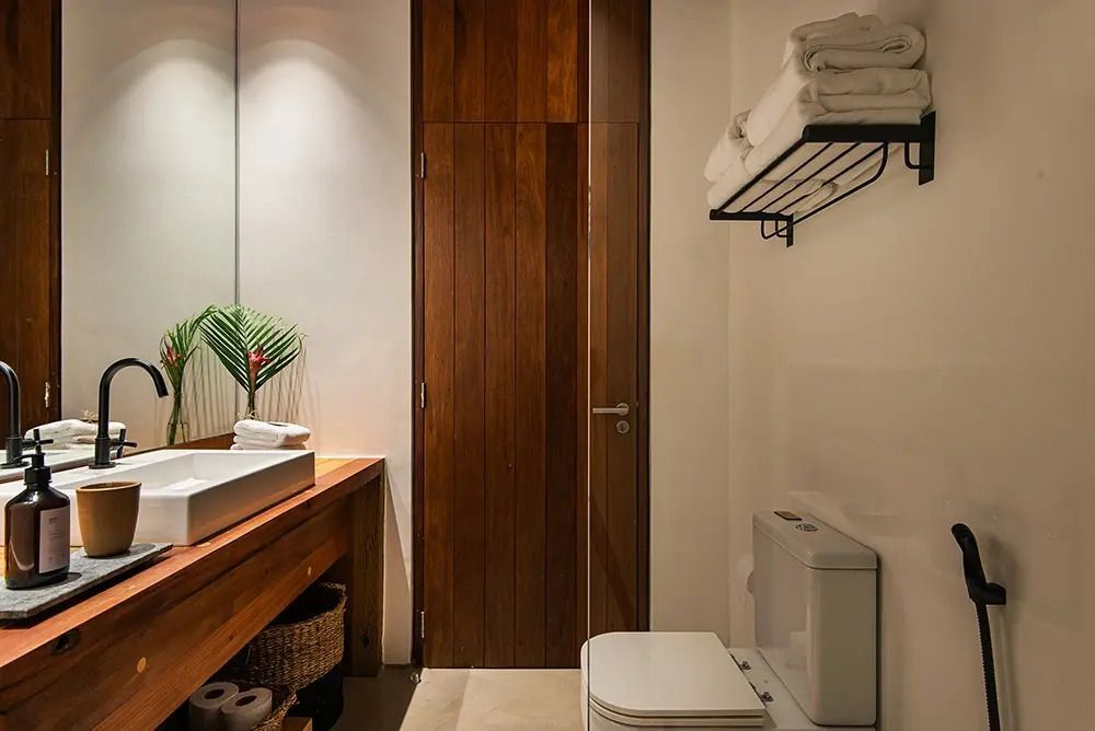 Modernes Badezimmer mit hölzernem Waschtisch und Handtüchern auf Regal