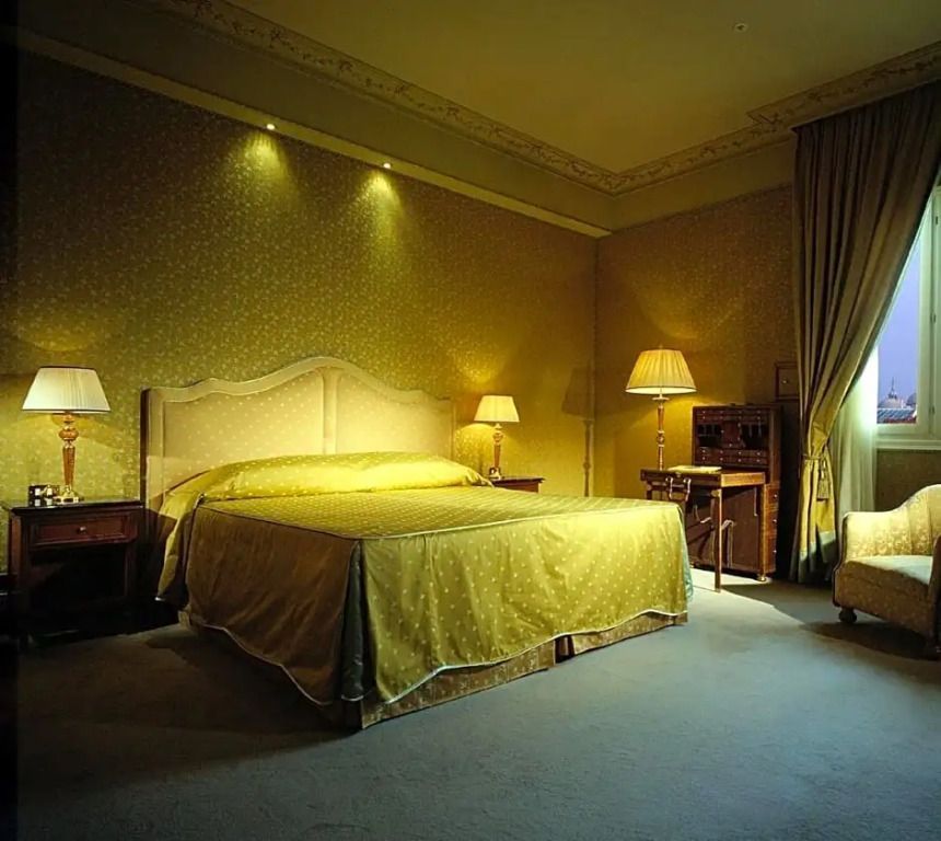 Geräumiges Zimmer mit elegantem Doppelbett und klassischem Dekor im Deluxe Doppelzimmer