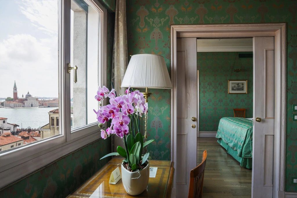 Elegante Executive Suite mit Orchidee und grünem Tapetendesign