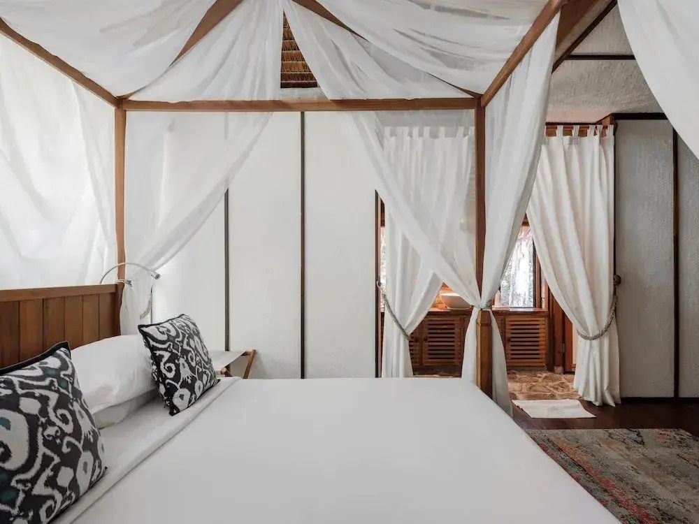 Geräumiges Zimmer mit Himmelbett und stilvoller Dekoration im Bawah Reserve