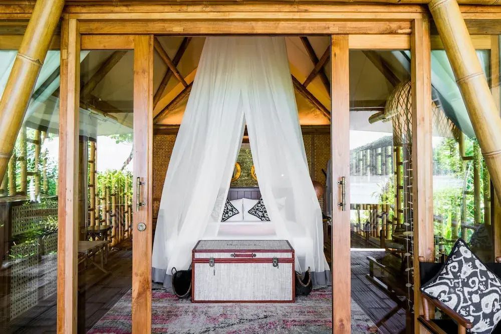 Bungalow mit offenem Himmelbett und umgebender Natur im Bawah Reserve