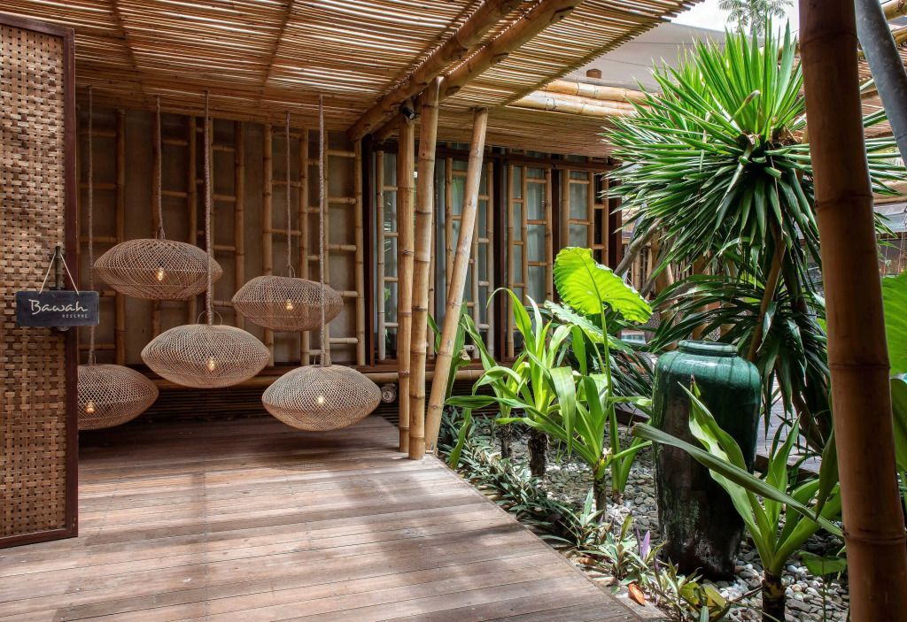 Terrasse einer Deluxe Villa mit Bambuslampen und üppigem Grün