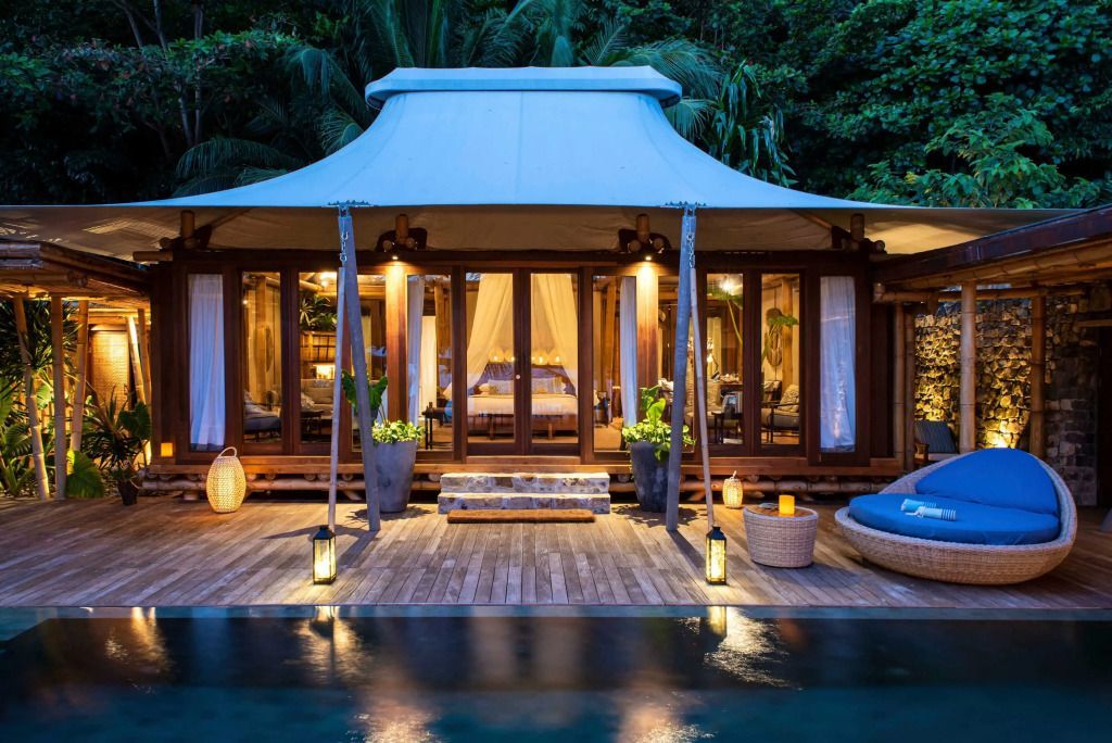 Beleuchtete Deluxe Villa mit Pool in tropischer Nachtatmosphäre