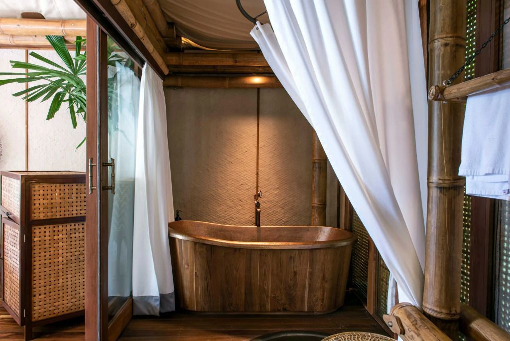 Holzbadewanne in luxuriösem Badezimmer einer Deluxe Villa mit Vorhängen