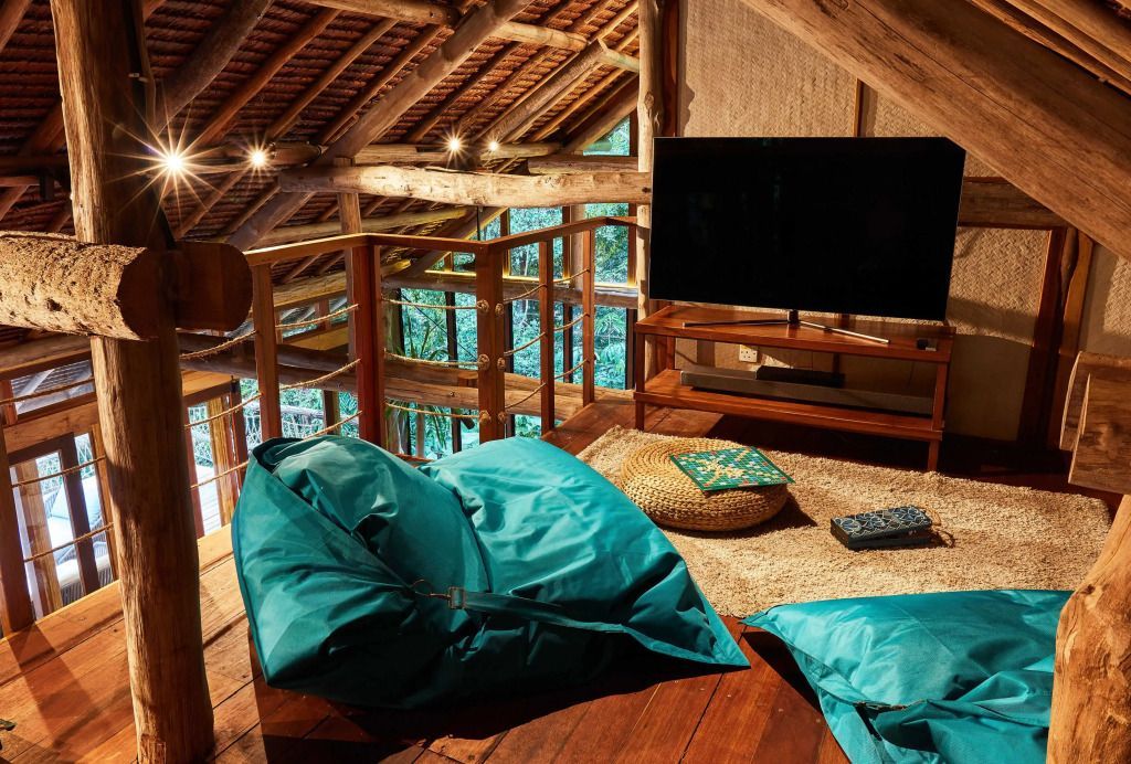 Gemütlicher Dachboden mit Sitzsäcken und Flachbildfernseher in einer Holzstruktur.