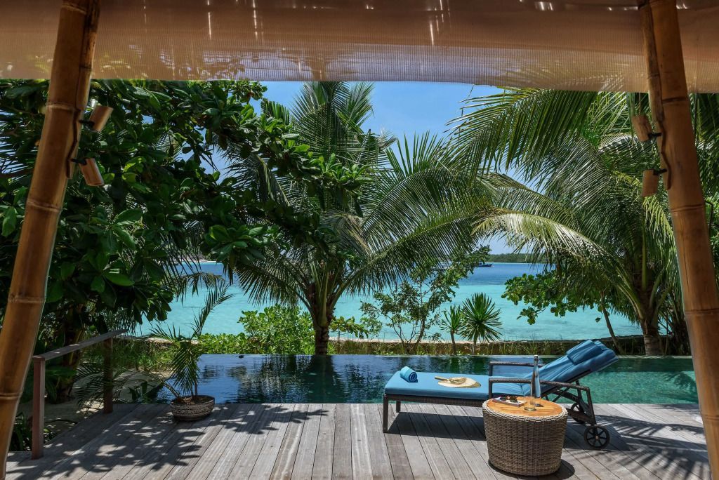Panoramablick von einer Terrasse auf den blauen Ozean und grüne Palmen