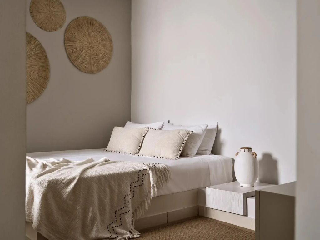 Modernes Schlafzimmer mit Doppelbett und dekorativen Wanddetails.