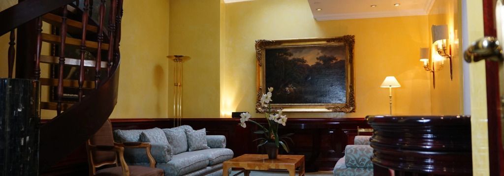 Elegante Sitzecke mit großem Gemälde in der stilvollen Hotellounge.