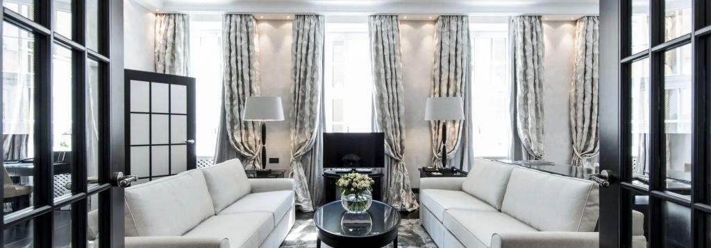 Luxuriöser Wohnbereich mit Sofas, Vorhängen und modernem Fernseher