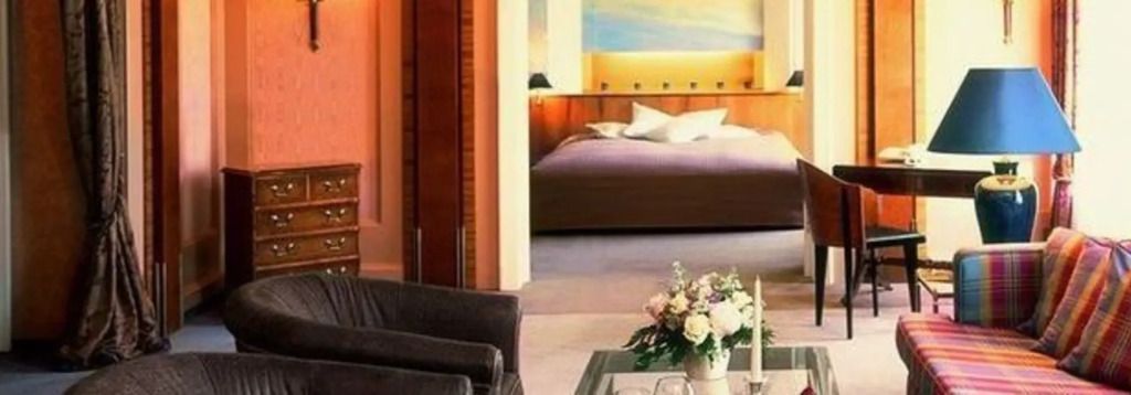 Elegantes Wohnzimmer mit Couch und Blick auf ein gemütliches Schlafzimmer