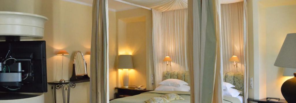 Elegantes Schlafzimmer mit Baldachinbett und sanfter Beleuchtung in der Bavarian Suite