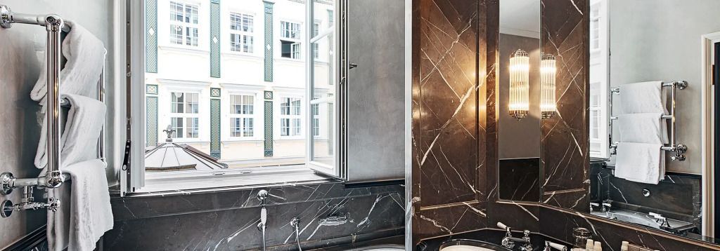 Modernes Badezimmer mit Marmorwänden und Fensterblick im Hotel