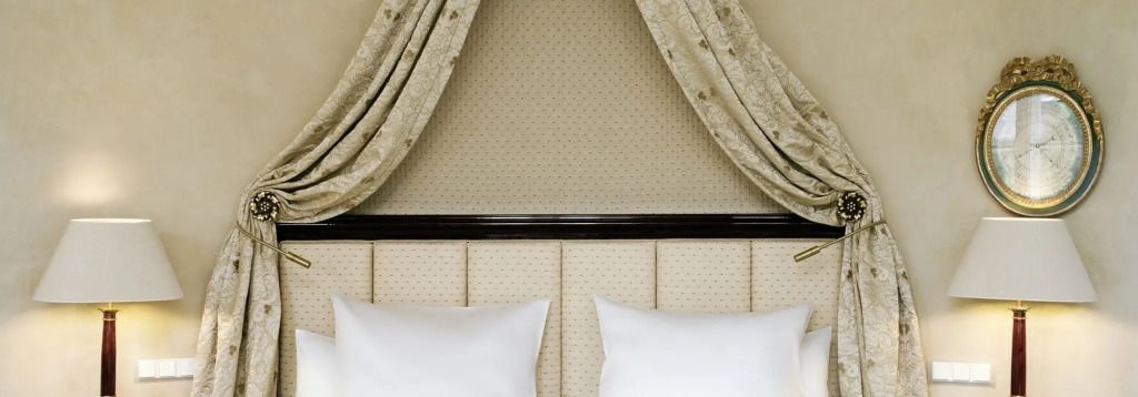 Elegantes Schlafzimmer-Design mit gepolstertem Kopfteil und dekorativen Vorhängen