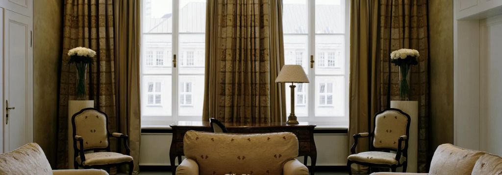 Gemütliche Sitzecke mit großer Fensterfront und stilvoller Tischlampe