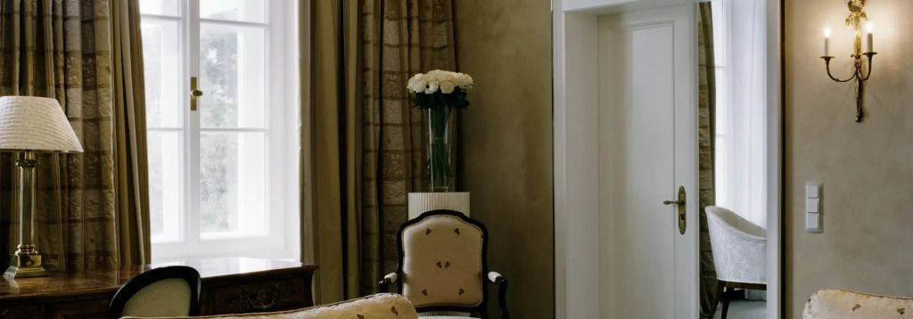 Klassischer Stuhl neben einer hohen Vase mit weißen Blumen