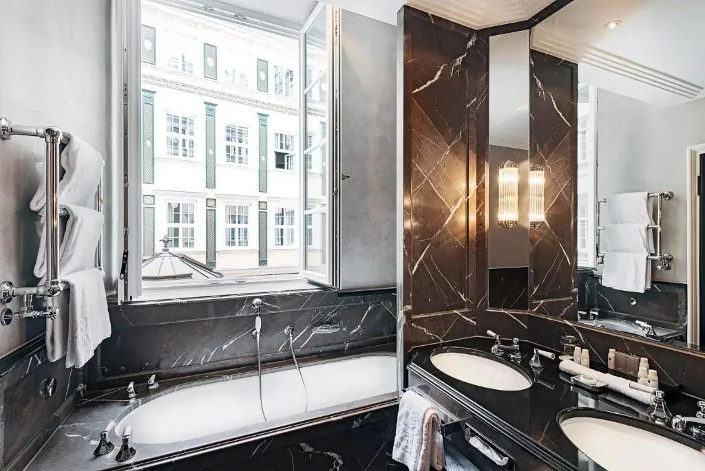 Luxuriöses Badezimmer mit Marmordesign und großer Fensterfront