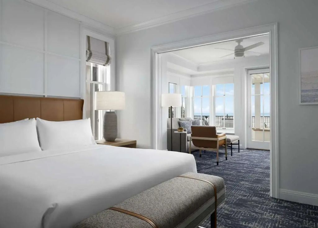 Helles Schlafzimmer mit Doppelbett und Blick auf den Balkon mit Meerblick