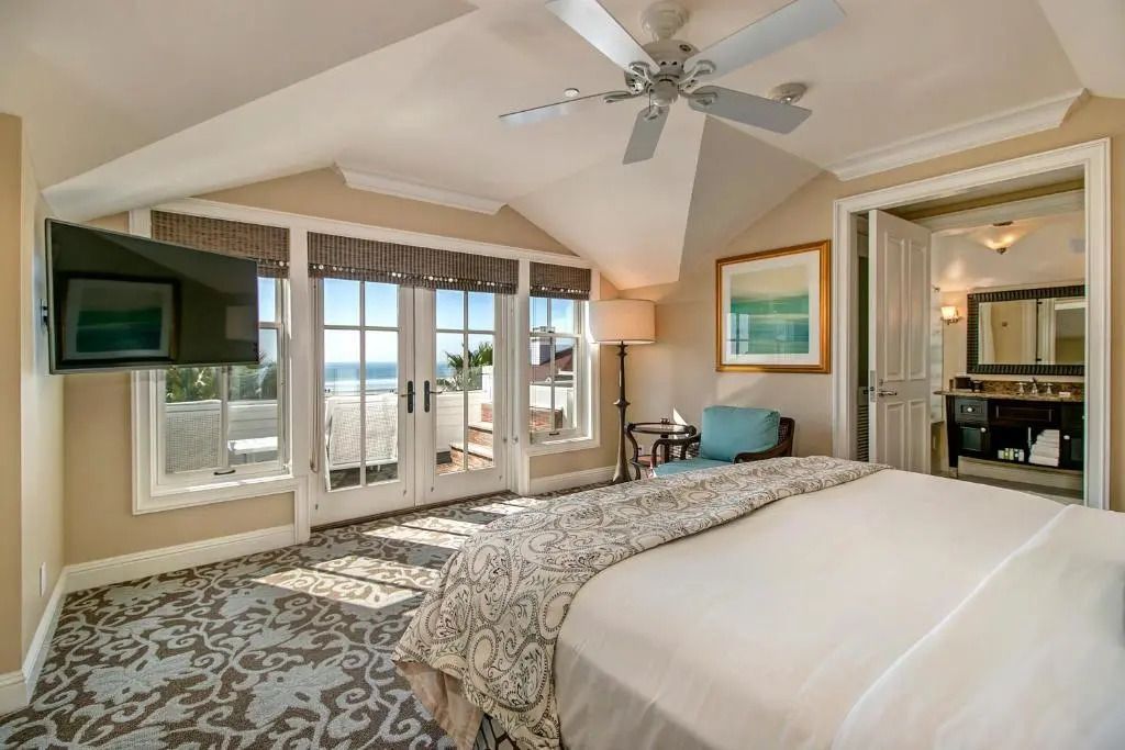 Helles Schlafzimmer mit großem Fenster und Meerblick in einer Suite