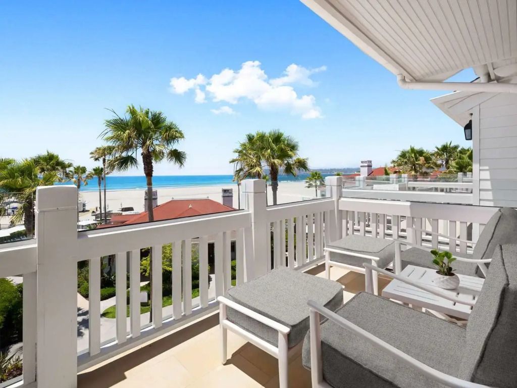 Terrasse mit Blick auf den Strand und Palmen im Beach Village