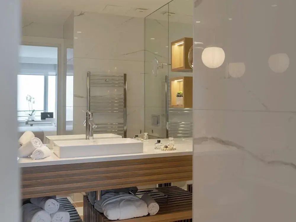 Modernes Badezimmer mit großem Spiegel, Waschbecken und luxuriösen Details