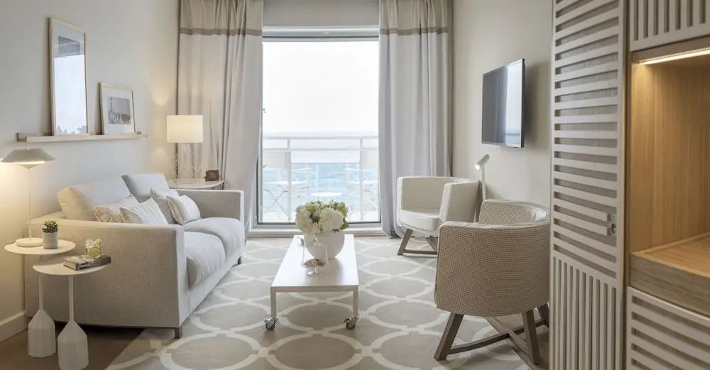 Wohnbereich mit Sofas, modernem Dekor und Meerblick durch Fenster