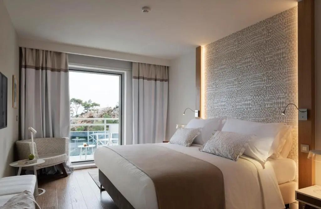 Schlafzimmer mit großem Bett und Balkon mit Meerblick