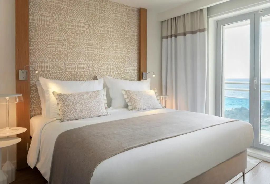 Komfortables Schlafzimmer mit großem Doppelbett, weiche Kissen, Zugang zum Balkon.