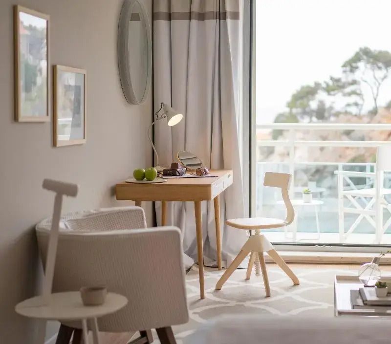 Heller Schreibtischbereich im Zimmer mit Zugang zum Balkon