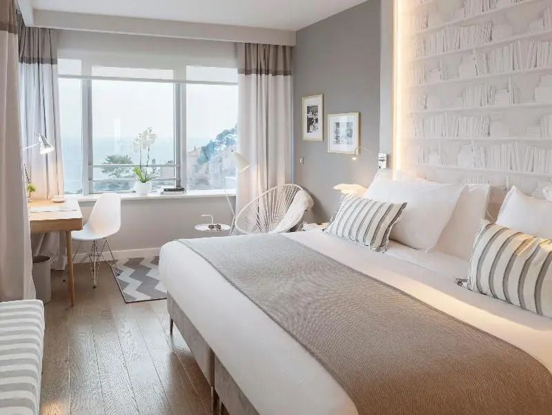 Modernes Doppelzimmer mit großem Fenster und Meerblick