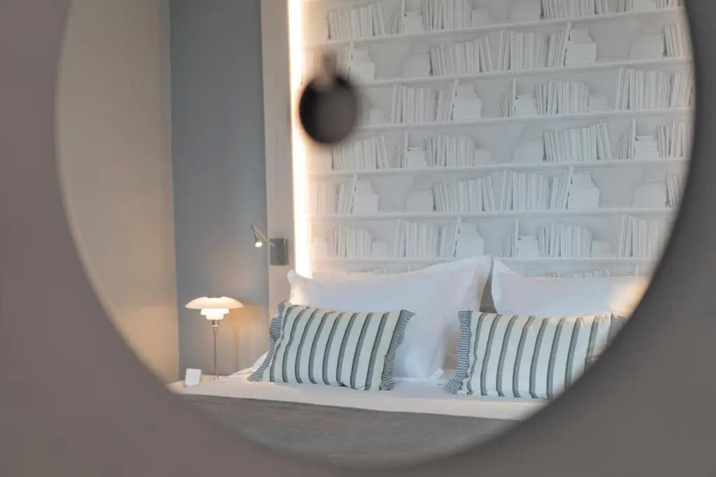 Bett mit Kissen vor einer dekorativen Bücherregalwand