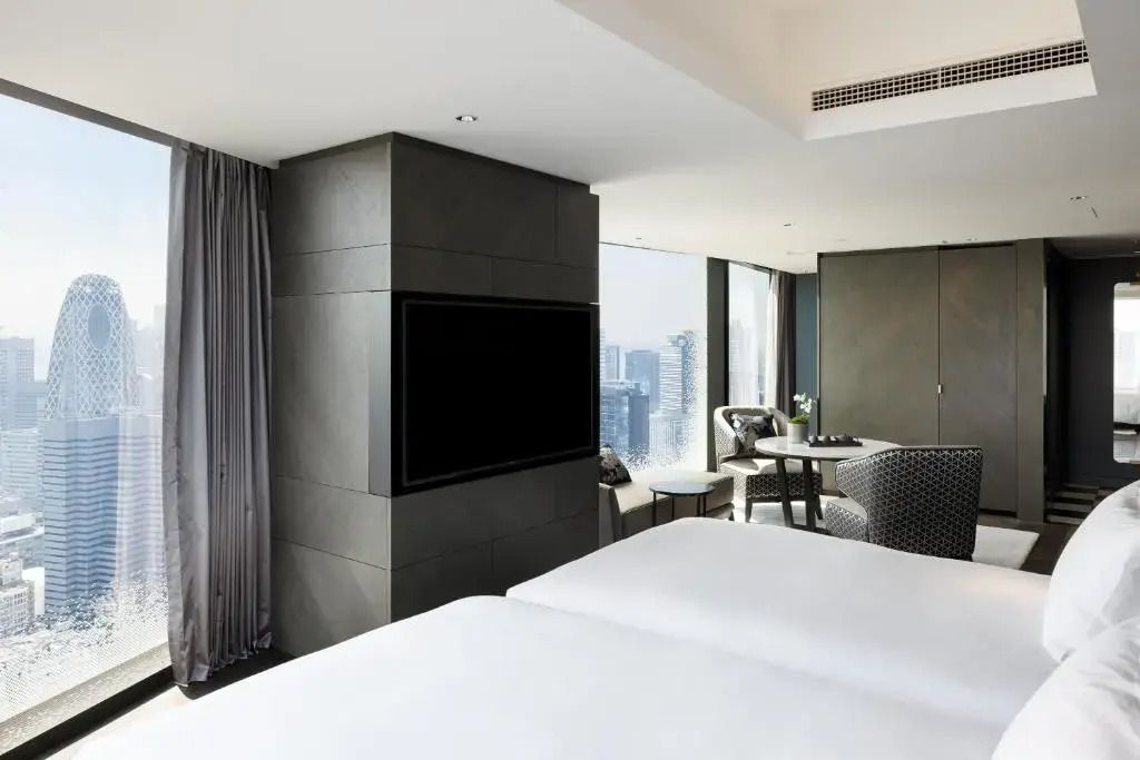Helles Zimmer mit zwei Einzelbetten und Blick auf die Skyline am Tag