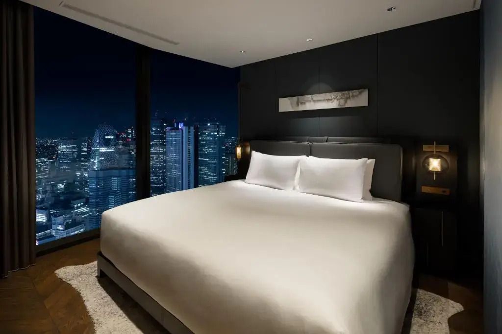 Luxuriöses Schlafzimmer mit großem Bett, Stadtblick und Nachtbeleuchtung