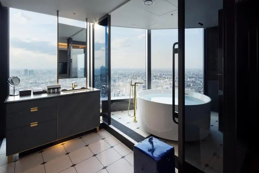 Freistehende Badewanne in einem modernen Bad mit Panoramafenster und beeindruckendem Stadtblick