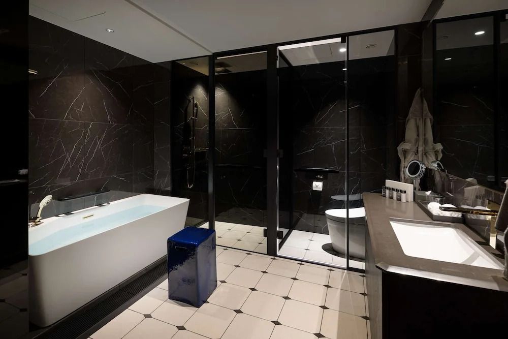 Luxuriöses Badezimmer mit Badewanne, moderner Dusche und stilvollem Waschbeckenbereich.