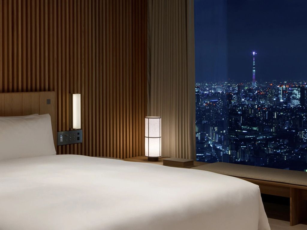 Luxuriöses Doppelbett im Kaze Penthouse mit Blick über die beleuchtete Stadt Tokio.