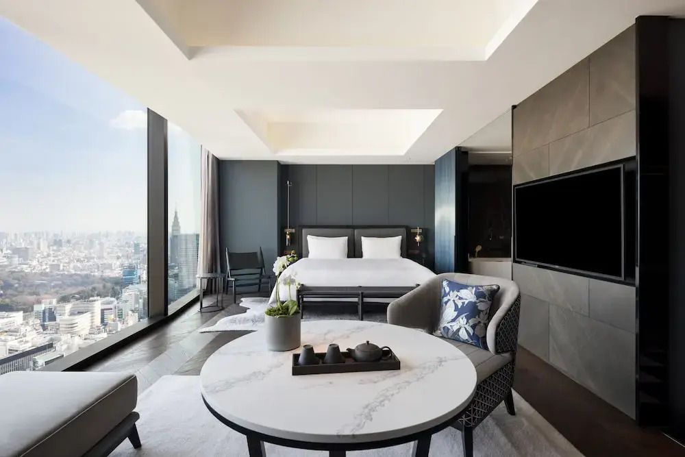 Helles Hotelzimmer mit Doppelbett und großem Fenster mit Tokio-Blick