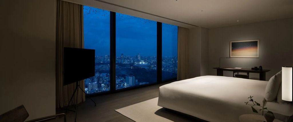 Penthouse-Zimmer mit großem Fenster und Blick auf die erleuchtete Skyline von Tokio bei Nacht