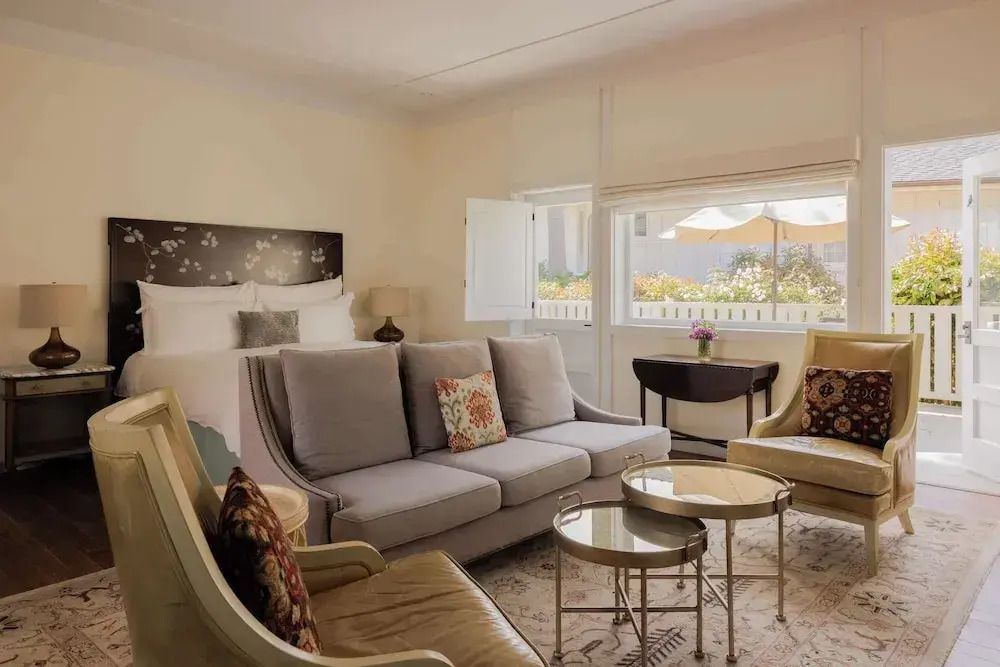 Gemütlicher Wohnbereich mit Sofa, Sesseln und Dekorationselementen in hellem Raum.