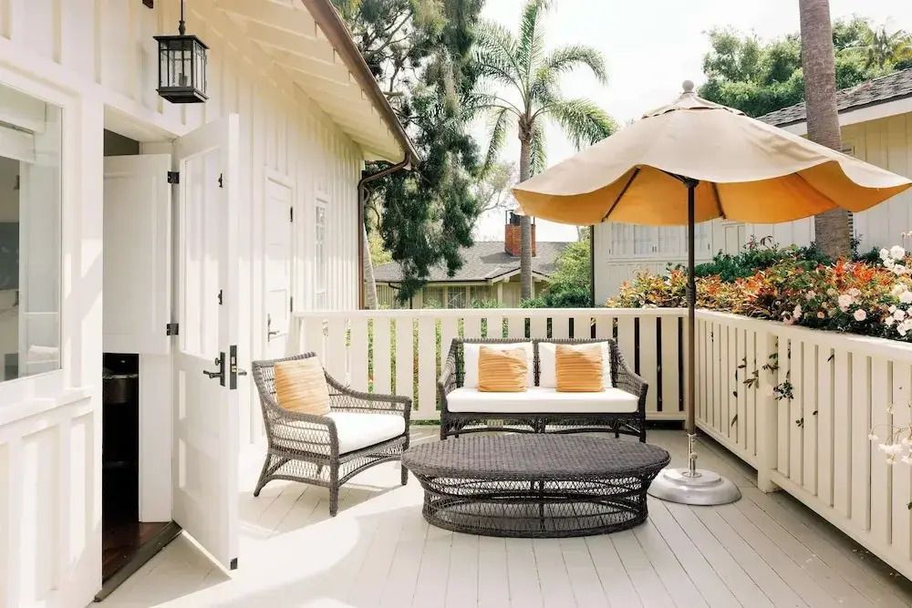 Sonnige Terrasse mit Sitzmöbeln und orangefarbener Markise in ruhiger Umgebung.