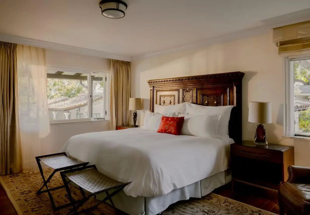 Einladendes Schlafzimmer mit Doppelbett in der Hummingbird Suite mit hellen Farben