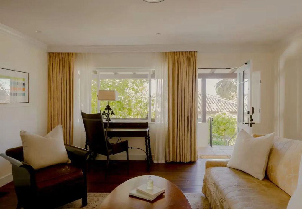 Helle Suite mit Sitzbereich und Blick auf die Terrasse in der Hummingbird Suite
