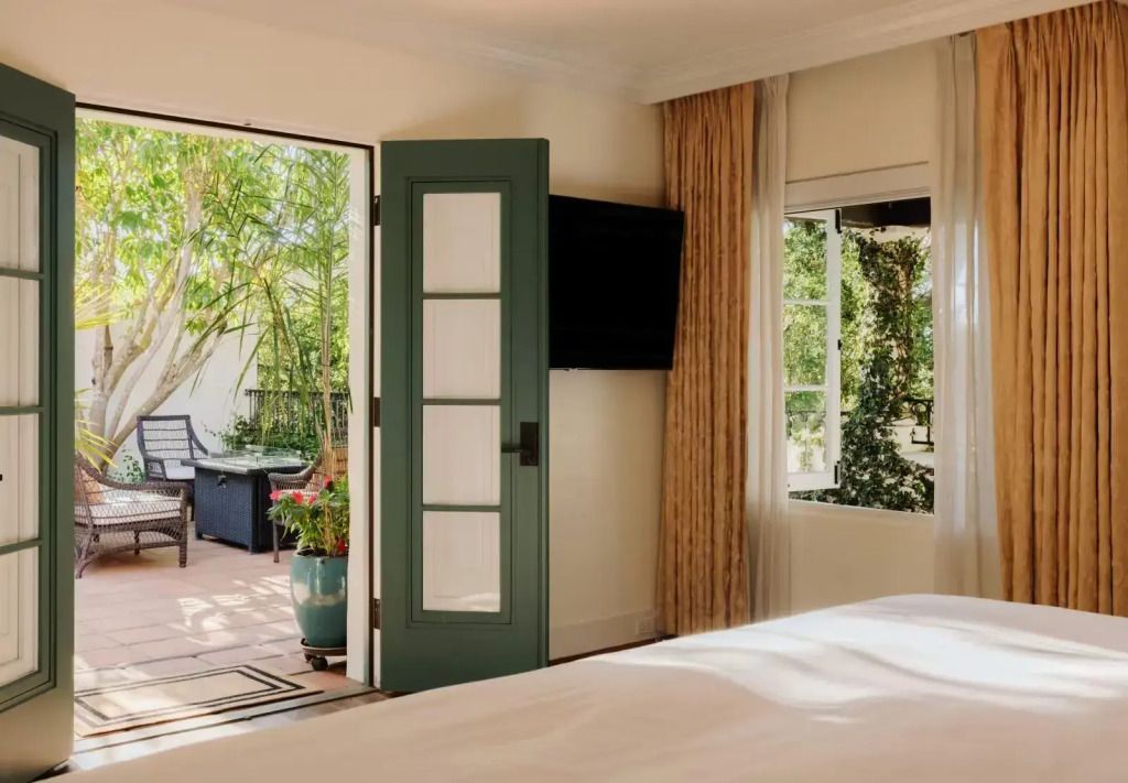 Suite mit Blick auf eine private Terrasse, helle Türen und natürliche Umgebung