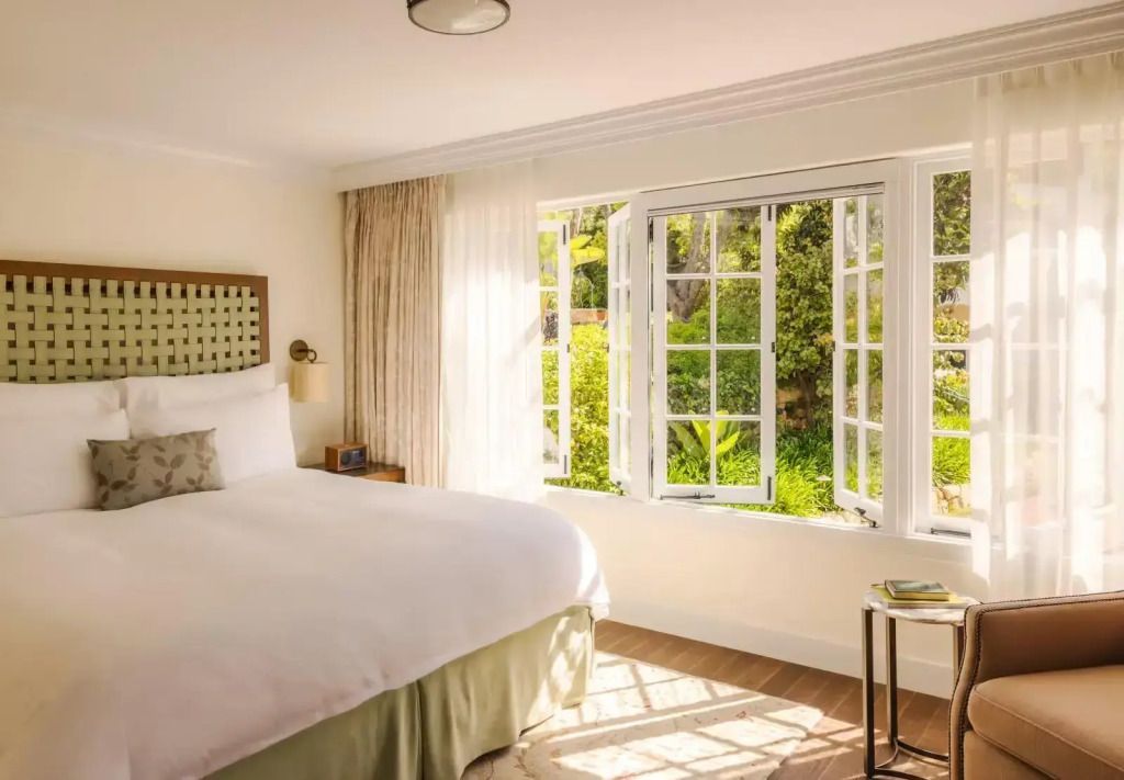 Gemütliches Schlafzimmer mit Doppelbett und offenem Fenster zum Garten