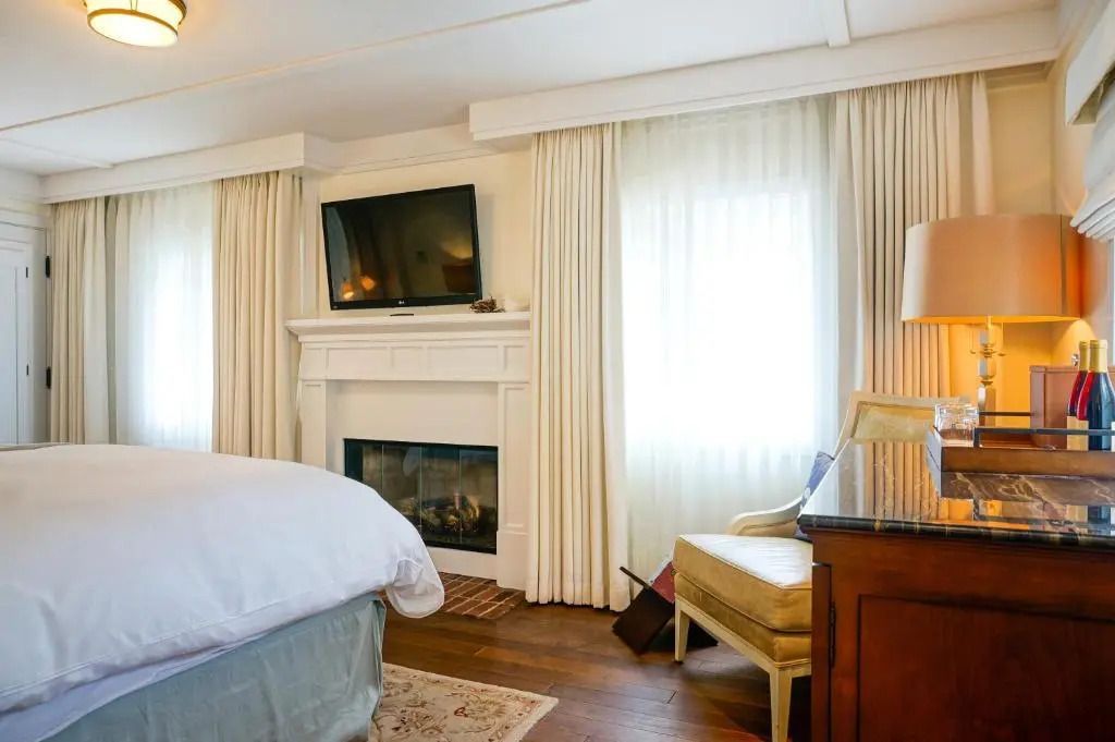 Zimmer mit Kamin, Flachbild-TV und eleganten Vorhängen im Superior Doppelzimmer.