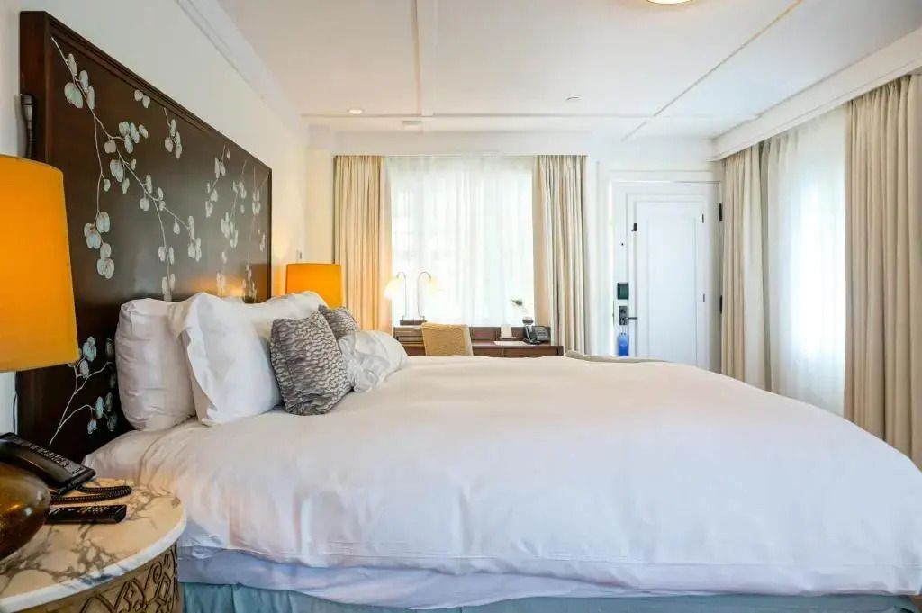 Geräumiges Doppelzimmer mit großem Bett, helle Vorhänge und Schreibtisch