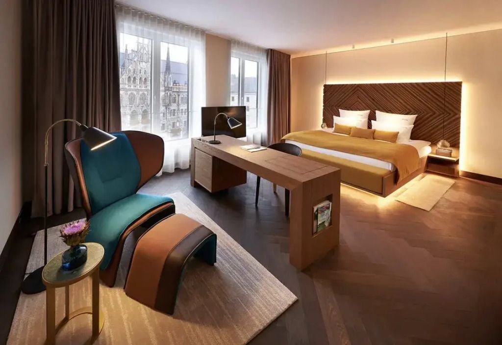 Junior-Suite mit Doppelbett und Schreibtisch mit Blick auf die Kirche
